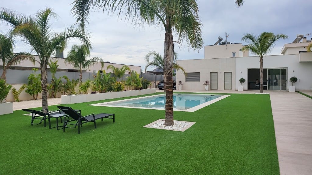 Jardín moderno con césped artificial premium y piscina rectangular en Alicante