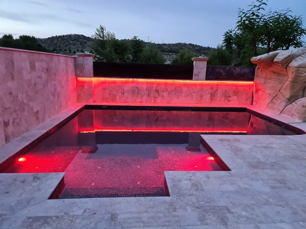 Piscina iluminada en rojo intenso para ambiente exclusivo