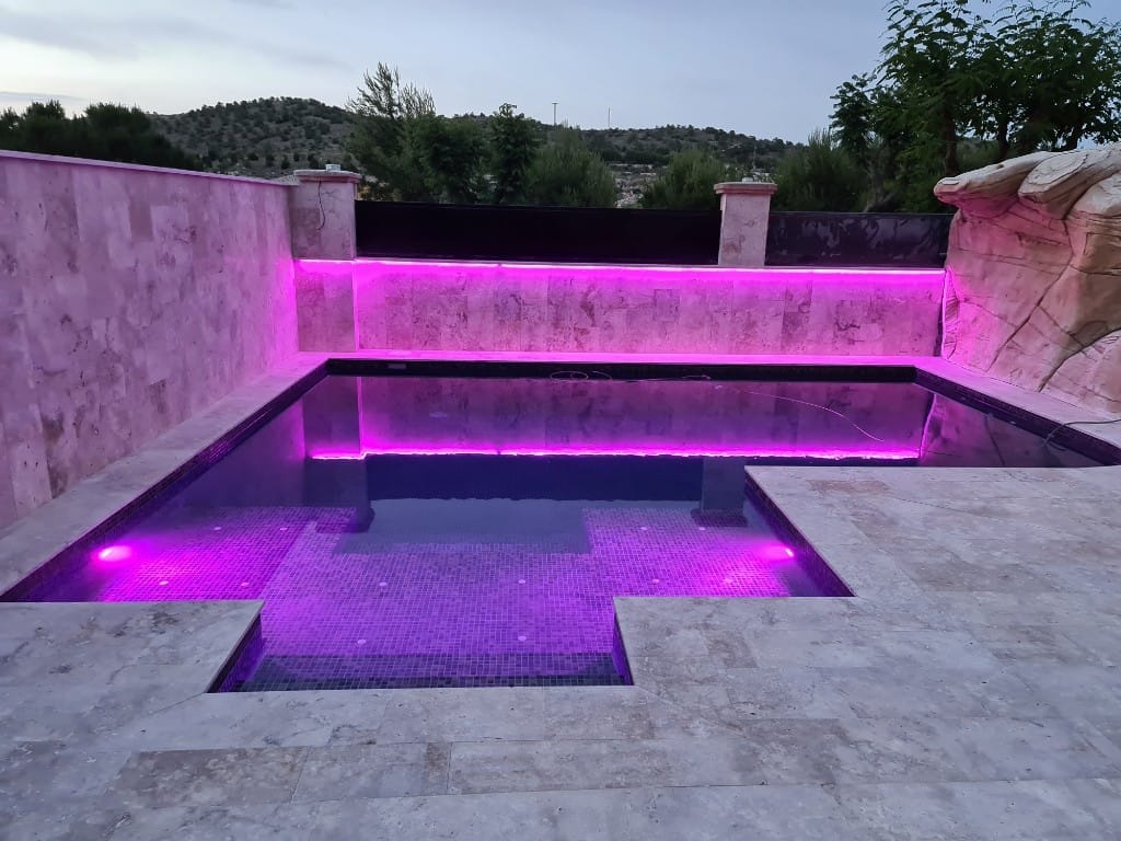 Piscina con iluminación LED rosa magenta para eventos exclusivos